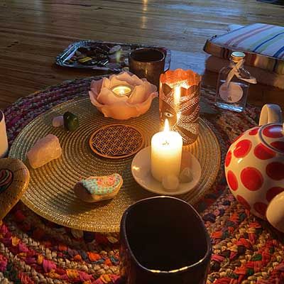 Bougies et objets posés sur un tapis tressé, installés pour un soin