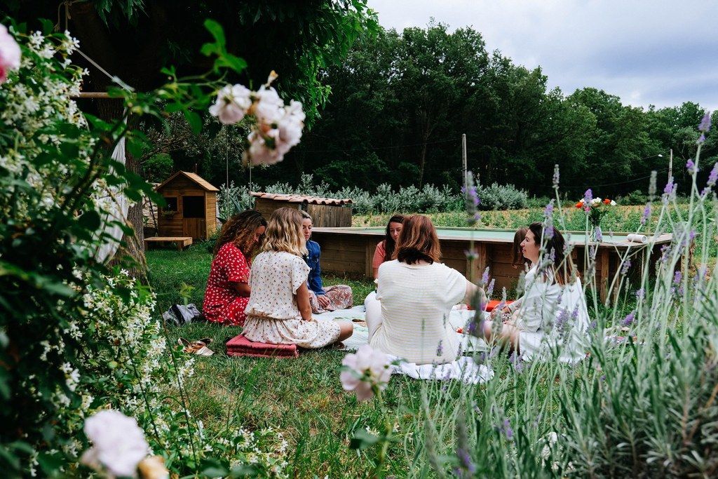 Des femmes assises dans l'herbe d'un jardin fleuri